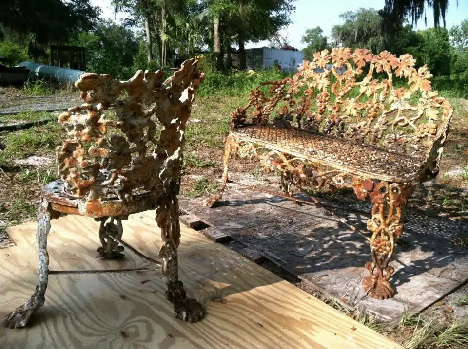 Rusted cast iron garden bench and chair before sandblasting