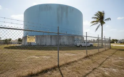 Concrete water storage tank behind a chain-link fence in Florida