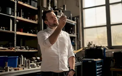 Manager examining a part in a workshop